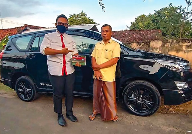 SERAH TERIMA: Salah seorang warga Desa Sumurgeneng saat menerima mobil dari perwakilan diler. (Jawa Pos Radar Tuban) - Image