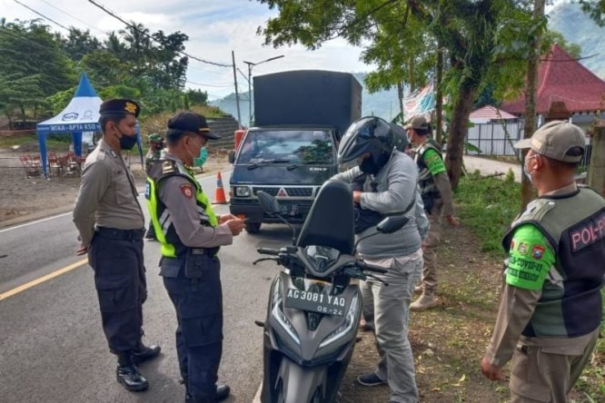 Petugas gabungan memeriksa kelengkapan surat dan barang bawaan pengendara yang melintas perbatasan Trenggalek-Ponorogo di jalur provinsi Desa Nglinggis, Trenggalek, Sabtu (13/3). Istimewa/Antara - Image