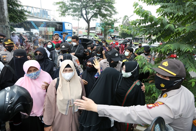 Personel Polri membubarkan massa pendukung saat berlangsungnya sidang perdana kasus pelanggaran protokol kesehatan dengan terdakwa Rizieq Shihab di Pengadilan Negeri (PN) Jakarta Timur, Jakarta, Selasa (16/3/2021). Sidang tersebut beragendakan pembacaan d - Image