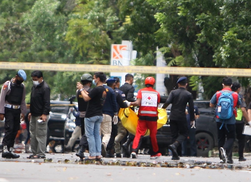 Petugas dari Gegana Brimob Polda Sulsel membawa kantong mayat yang berisi serpihan tubuh untuk diperiksa. Sebuah bom meledak di gerbang masuk Gereja Katedral Minggu, 28 Maret -- TAWAKKAL/FAJAR - Image