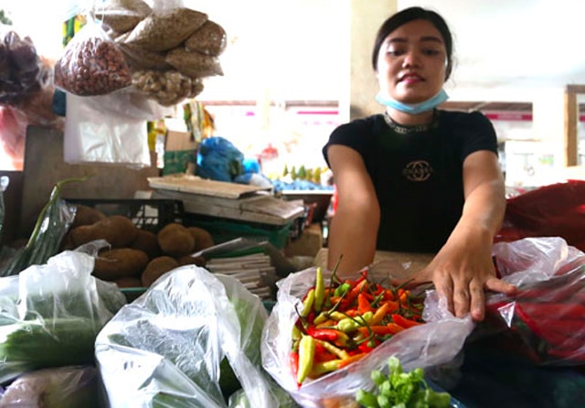 MELAMBUNG TINGGI: Mia Dadang, penjual sayuran di Pasar Modern CitraLand, menjual cabai kini tak bisa banyak karena harganya semakin melejit, yakni Rp 150 ribu hingga Rp 170 ribu. (Guslan Gumilang/Jawa Pos) - Image