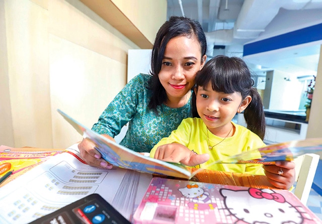 BANYAK MANFAAT: Luangkan waktu minimal 15 menit sehari untuk membaca bareng dan sediakan buku di tempat anak sering beraktivitas. (Allex Qomarulla/Jawa Pos) - Image