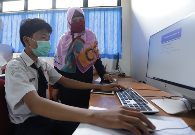 Sejumlah siswa SMPN 240 melakukan ujian akhir sekolah secara tatap muka dengan memperhatikan protokol kesehatan di Jakarta, Selasa (6/4/2021). Beberapa siswa melakukan ujian secara tatap muka dengan diawasi guru dikarenakan banyaknya siswa yang mengalami - Image