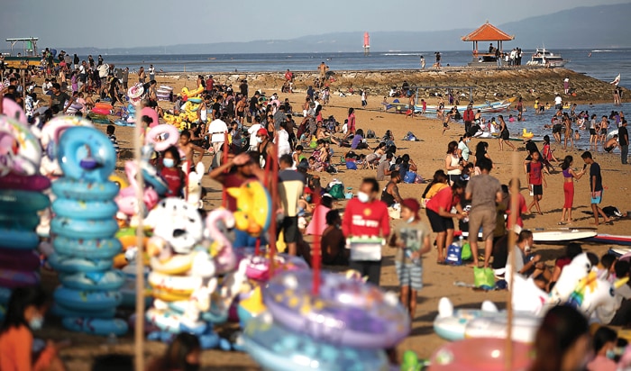 TERBATAS DI ZONA HIJAU: Wisatawan domestik memadati Pantai Sanur, Bali (15/4). Pandemi mengakibatkan jumlah kunjungan turis asing dan domestik ke Bali turun. (HENDRA EKA/JAWA POS) - Image