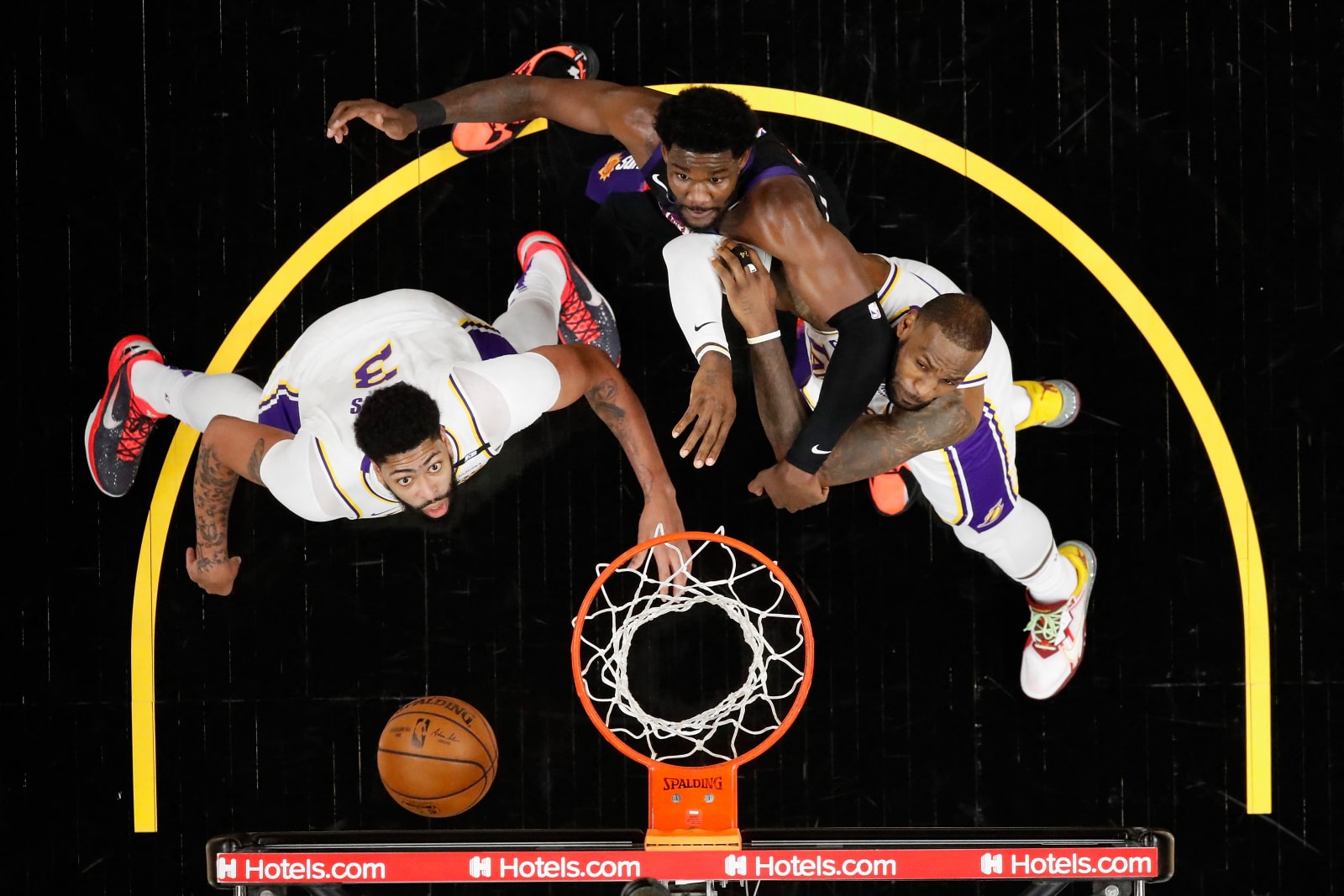 : Anthony Davis(kir) dan LeBron James (kanan) berusaha memblok Deandre Ayton. CHRISTIAN PETERSEN/AFP PHOTO - Image