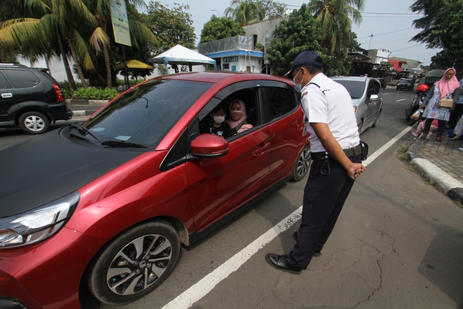 Pengunjung melintas didepan pengumuman penutupan sementara kawasan TMII di Jakarta, Minggu (16/5/2021). Pemprov DKI Jakarta memutuskan menutup sementara tempat wisata TMII, Ragunan dan Ancol hingga 17 Mei mendatang guna melakukan penguatan protokol keseha - Image