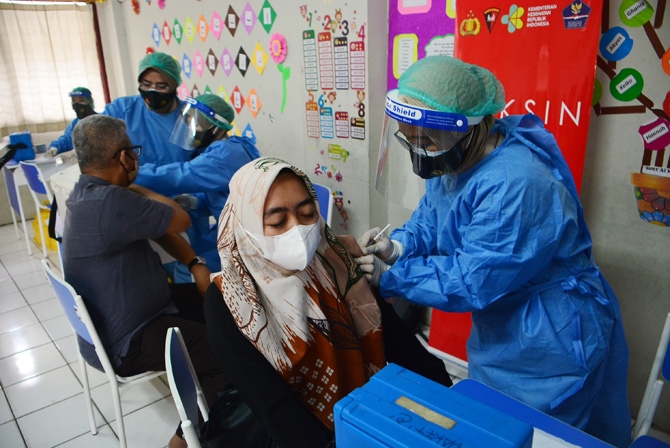 Tenaga Medis memberikan vaksinasi covid-19 kepada tenaga pengajar se kota Depok di SDIT Al Muhajirin, Depok, Jawa Barat, Selasa (18/05-2021). Menteri Pendidikan dan Kebudayaan Nadiem Makarim menyebutkan dalam upaya mempercepat vaksinasi untuk tenaga pend - Image