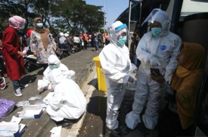 Petugas kesehatan melakukan tes cepat antigen di akses keluar Jembatan Suramadu, Surabaya. Didik Suhartono/Antara - Image