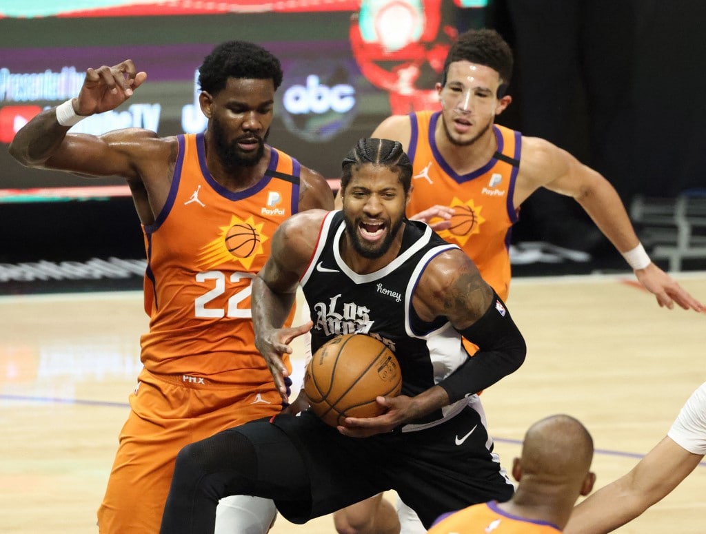 LOS ANGELES, CALIFORNIA - JUNE 24: Paul George #13 of the LA Clippers drives between Deandre Ayton #22 and Devin Booker #1 of the Phoenix Suns during the second half of game three of the Western Conference Finals at Staples Center on June 24, 2021 in Los - Image