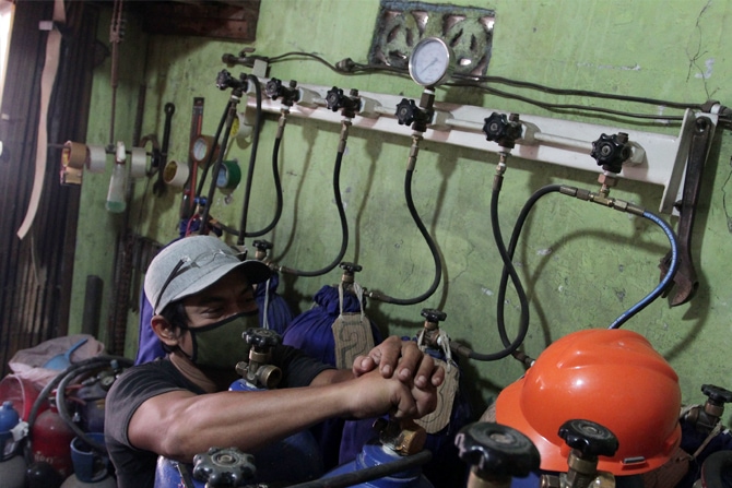 Pekerja melayani pelanggan isi ulang oksigen di agen isi ulang oksigen kawasan Joglo Raya, Jakarta, Kamis (17/6/2021). Permintaan oksigen untuk kebutuhan medis rumahan meningkat 50 persen sejak pandemi covid-19 mewabah di Jakarta. Rata-rata warga mengguna - Image