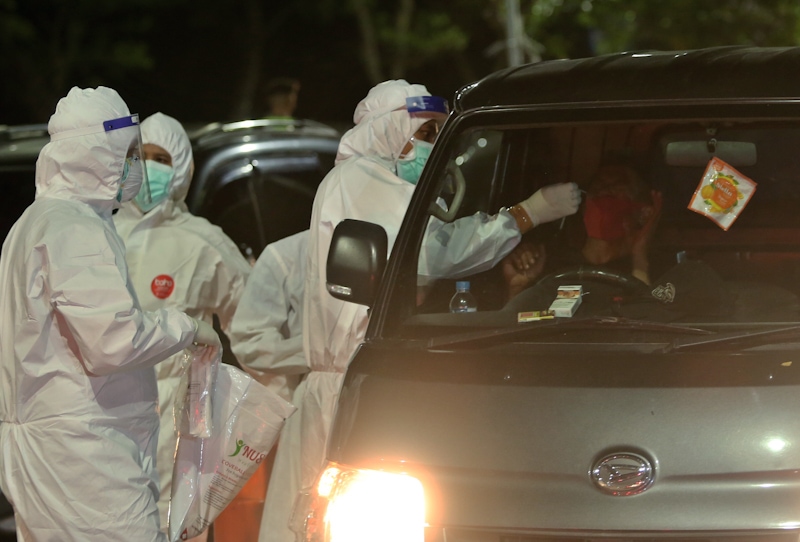 Petugas melakukan swab pada pengendara yang memasuki Kota Surabaya melali akses Suramadu pada senin dini hari kemarin (7/6). Penyekatan warga masuk dari Madura ke Surabaya terus diperketat untuk mengantisipasi penyebaran virus Covid-19 yang sebelumnya sem - Image