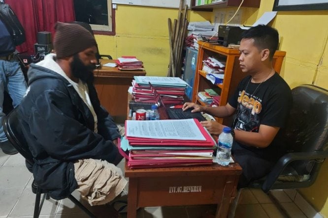 Penyidik Polres Merauke memeriksa tersangka EKM, penyebar ujaran kebencian di media sosial, Merauke, Papua, Rabu (9/6). Satgas Operasi Nemangkawi/Antara - Image