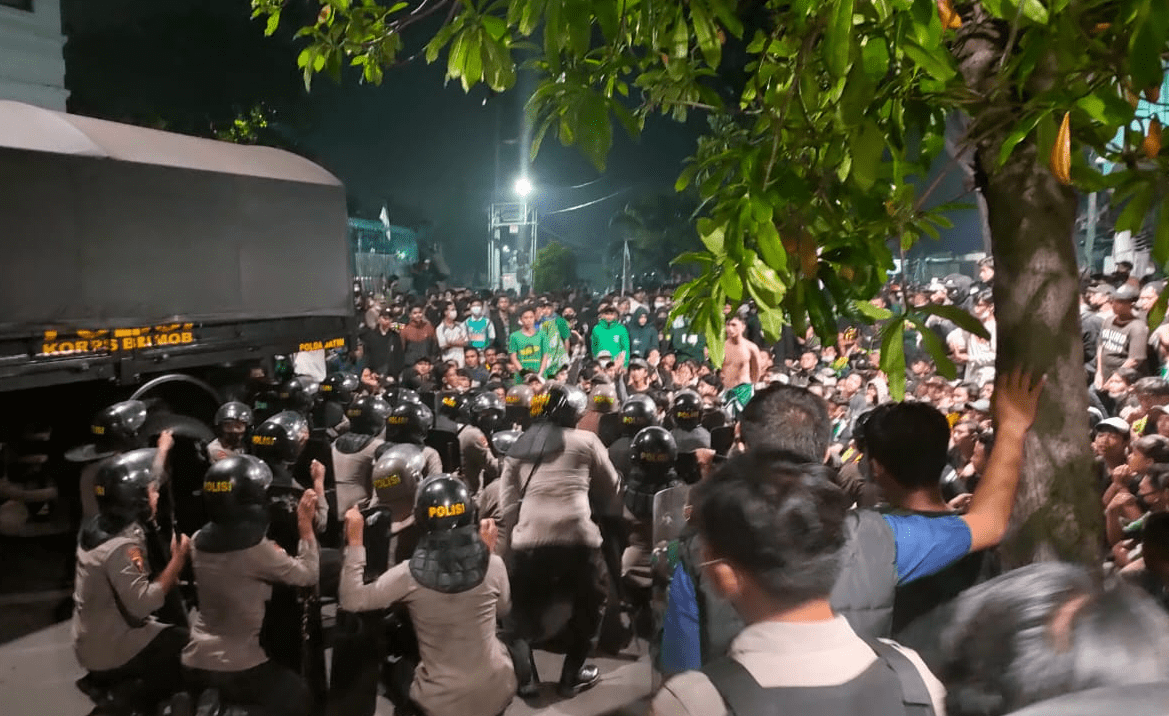 Polisi berusaha menahan Bonek yang merangsek menuju kawasan Stadion Gelora 10 November, Surabaya pada Jumat (18/6) dini hari. Foto: Rafika Yahya/JawaPos.com - Image