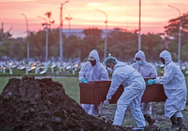 TARGET SEGERA LANDAI: Petugas berbaju hazmat memakamkan jenazah dengan prosedur Covid-19 di TPU Keputih kemarin (22/6). Pemakaman jenazah Covid-19 melonjak pada dua minggu terakhir. (Alfian Rizal/Jawa Pos) - Image
