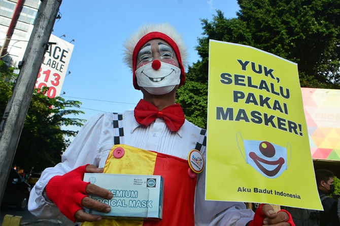 Sejumlah anggota komunitas Aku Badut Indonesia (ABI) melakukan aksi dengan mambawa poster di kawasan Fatmawati Jakarta, Senin (12/7/2021). Aksi tersebut untuk mengajak masyarakat menerapkan protokol kesehatan untuk mencegah penyebaran COVID-19 yang terus - Image