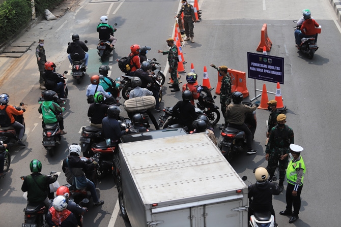 Petugas gabuungan saat memeriksa kendairaan bermotor yang hendak melintas menuju underpass Mampang, Jakarta, Kamis (15/7/2021). Personel gabungan Polda Metro Jaya, Kodam Jaya, dan Pemprov DKI menambah titik penyekatan selama Pemberlakuan Pembatasan Kegiat - Image