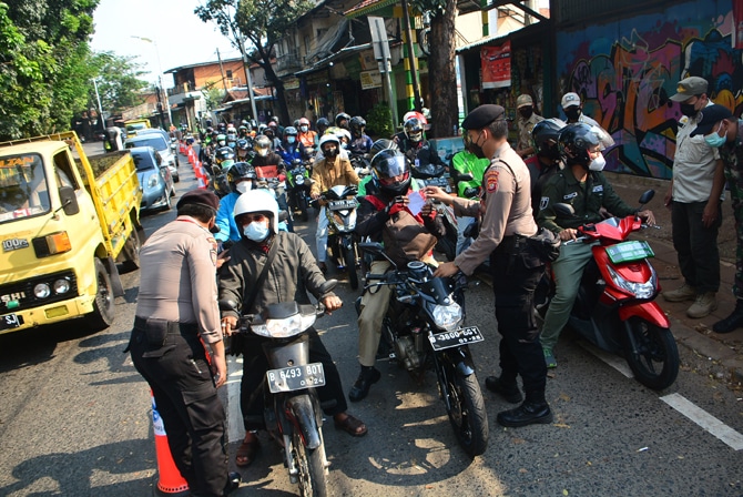 Pasukan gabungan TNI dan Polri memeriksa kendaraan bermotor di penyekatan perlintasan Lenteng Agung, Jakarta, Jumat (9/7/2021). Kepala Korps Lalu Lintas (Kakorlantas) Polri Inspektur Jenderal Istiono menyebut volume kendaraan di titik penyekatan PPKM Daru - Image