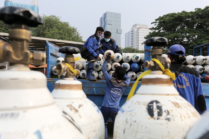 Sejumlah petugas menurunkan tabung oksigen dari truk di Posko Darurat Oxygen Rescue, kawasan Monumen Nasional (Monas), Jakarta, Senin (5/7/2021). Pemerintah Provinsi DKI Jakarta menyediakan posko tersebut untuk memenuhi kebutuhan oksigen di rumah sakit, m - Image