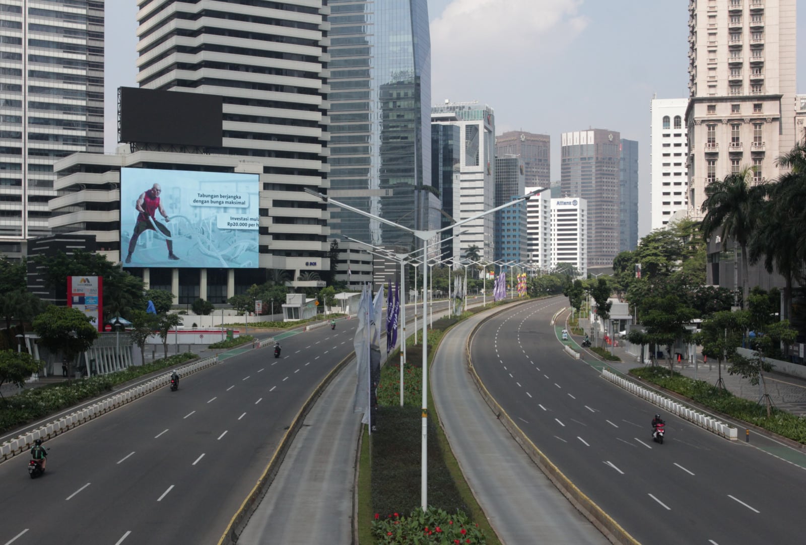 Suasana sepi lalu lintas saat Pemberlakuan Pembatasan Kegiatan Masyarakat (PPKM) Darurat di kawasan Jalan Jenderal Sudirman, Jakarta, Sabtu (3/7/2021). Petugas akan memberikan akses untuk melintas di titik penyekatan PPKM Darurat di 63 titik di wilayah Ja - Image