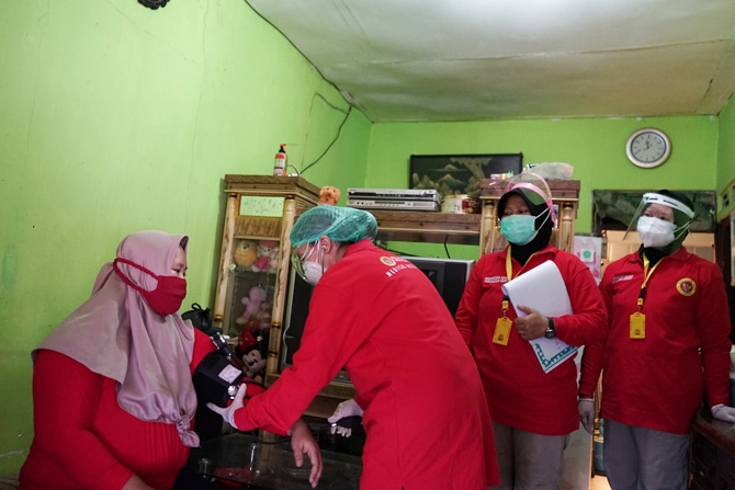 Petugas medis saat mendatangi rumah warga untuk menyuntikkan vaksin Covid secara door to door di kawasan Bogor, Jawa Barat, Rabu (14/7/2021). Metode vaksinasi Covid-19 secara door to door yang digunakan beberapa negara ini mampu meningkatkan partisipasi - Image