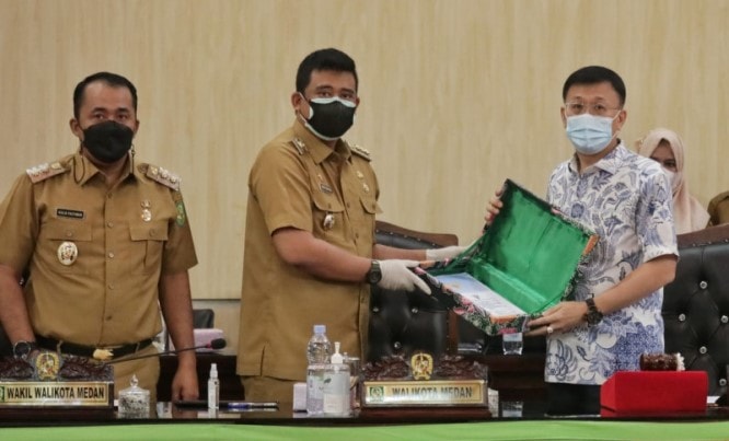 Wali Kota Medan Bobby Nasution (tengah) menyerahkan nota pengantar raperda kepada Ketua DPRD Medan Hasyim (kanan) di Gedung DPRD Kota Medan, Senin (19/7). Antara - Image