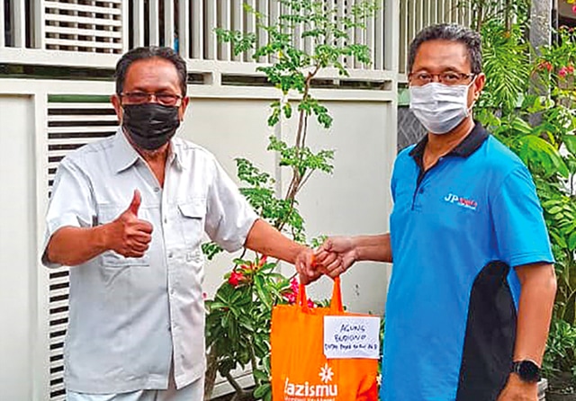 EMPATI: Petugas Lazismu membagikan paket bantuan bagi warga yang isoman. Sejak pandemi merebak, sejumlah organisasi keagamaan turun tangan membantu pemkot. (Ariski Prasetyo/Jawa Pos) - Image