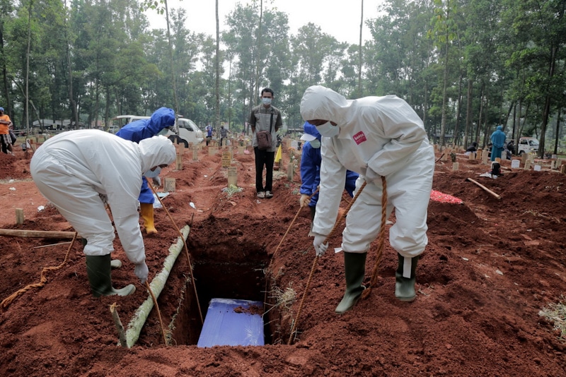 Petugas TPU memamkamkan pasien Covid-19 di TPU Cipenjo, Kabupaten Bogor, Rabu (14/07/2021). Para petugas masih menggunakan alat bantu pemakaman secara manual, sedangan jumlah korban meninggal karena Covid-19 terus bertambah--Foto: Imam Husein/Jawa Pos - Image