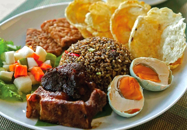 DENGAN PENDAMPING: Nasi goreng rawon yang sudah jadi bisa dilengkapi sajian lain. Seperti acar, telur asin, kerupuk, dan tempe. (Alfian Rizal/Jawa Pos) - Image