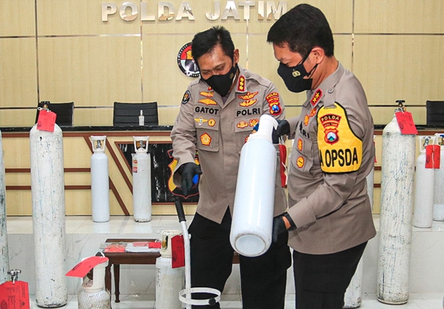 LEBIH MAHAL: Irjen Pol Nico Afinta (kanan) dan Kabidhumas Polda Jatim Kombespol Gatot Repli Handoko melihat tabung oksigen yang disita. (Dimas Maulana/Jawa Pos) - Image