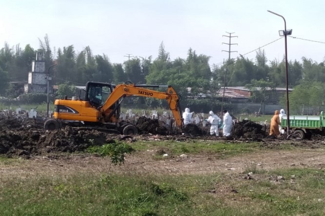 Sejumlah petugas melakukan pemakaman jenazah pasien terkonfirmasi positif Covid-19 di Tempat Pemakaman Umum (TPU) Keputih, Kota Surabaya, Jatim, Kamis (15/7). Abdul Hakim/Antara - Image