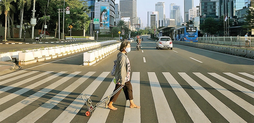 LALU LINTAS SEPI: Jalan Jenderal Sudirman, Jakarta, terlihat lengang menjelang pengumuman perpanjangan PPKM kemarin (25/7). (SALMAN TOYIBI/JAWA POS) - Image