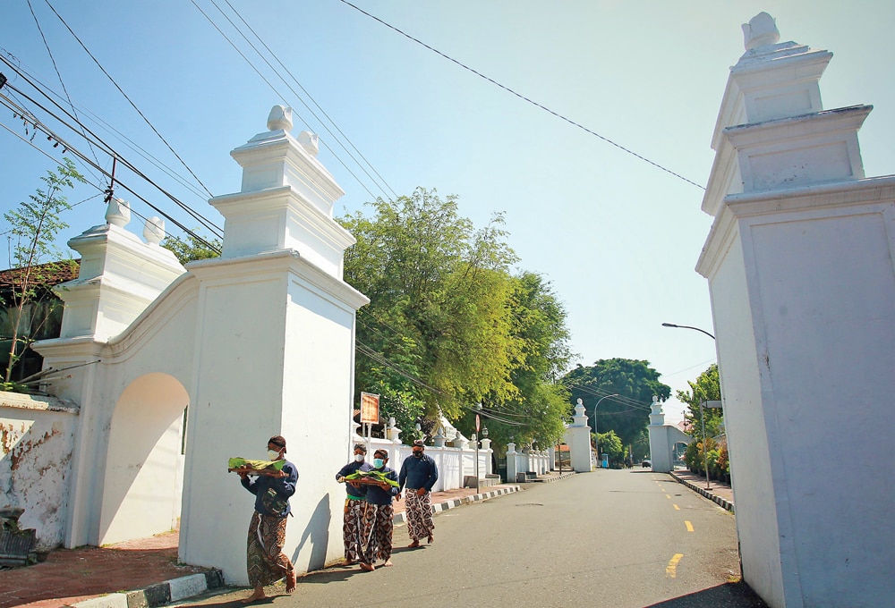 LENGANG: Abdi dalam membawa potongan daging sapi kurban Sri Sultan HB X dari kompleks Masjid Gedhe Kauman menuju Keraton Jogja kemarin (20/7). (GUNTUR ARGA TIRTANA/JAWA POS RADAR JOGJA) - Image