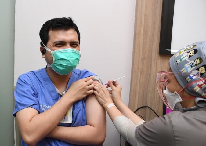 Seorang tenaga kesehatan menerima suntikan dosis ketiga vaksin COVID-19 sebagai booster di RSCM Jakarta, Ahad (18/7/2021), perlindungan dari risiko tertular. (ANTARA/Humas Kemenkes) - Image