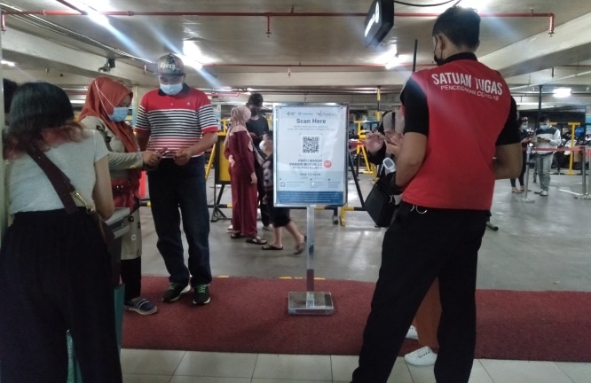 Calon pengunjung mal di Royal Plaza mengurus aplikasi PeduliLindungi. Rafika Yahya/JawaPos.com - Image