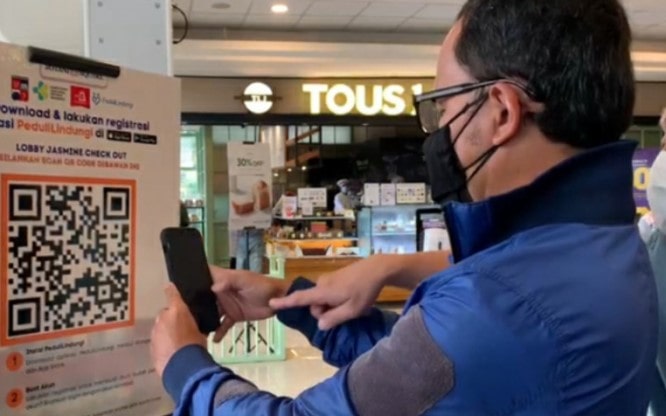 Wali Kota Bogor Bima Arya mencoba melakukan scan barcode sertifikat vaksin pada saat meninjau Mal Botani Kota Bogor, Sabtu (21/8). Pemkot Bogor/Antara - Image