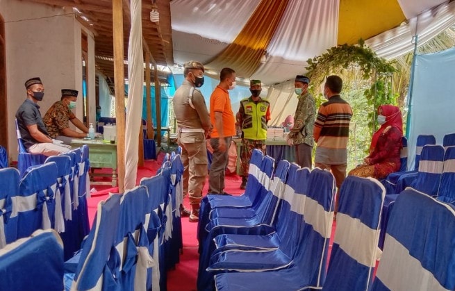 Petugas Satgas Covid-19 Tulungagung saat memberi pengertian kepada pemilik acara hajatan keluarga untuk menghentikan kegiatan dengan alasan menegah risiko penularan Covid-19 di Tulungagung. - Image