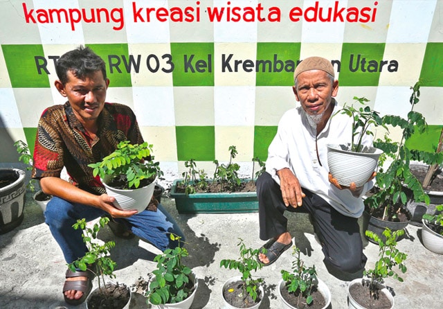 PRAKARSA WARGA: Usaha Edi Retmono (kiri) dan Suranto dalam menata Jalan Layar tidak sia-sia. Bersama seluruh warga, lingkungan kumuh di Jalan Layar berhasil diubah menjadi Kampung Kreasi Wisata dan Edukasi (KKWS). (Frizal/Jawa Pos) - Image