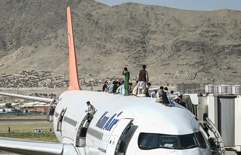PANIK: Ribuan warga Afghanistan memenuhi Bandara Kabul kemarin. Sebagian bahkan nekat ke atap pesawat. Mereka ingin keluar dari Kabul setelah kota itu tersebut dikuasai Taliban (AFP) - Image