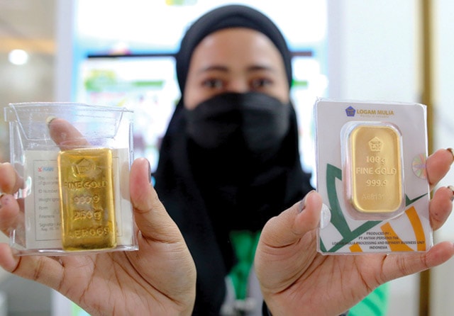 BUTUH TEMPAT MENYIMPAN: Logam mulia dengan bobot 100 gram dan 250 gram. (Salman Toyibi/Jawa Pos) - Image