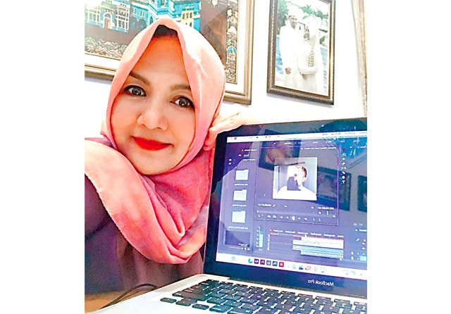 SATUKAN SEMANGAT: Azza Irene tengah memantau proses editing video Ngamen Online yang segera dirilis akhir bulan ini. (Azza Irene for Jawa Pos) - Image