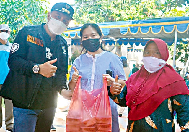 PENUH EMPATI: Yen Yen Widyawati (tengah) ketika bertemu Wali Kota Eri Cahyadi. Yen Yen giat memberikan bantuan makanan kepada warga isoman. (Fajar Tumanggor/Jawa Pos) - Image