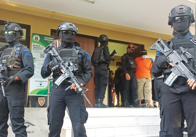 DIJAGA KETAT: Polisi mengawal tersangka kasus terorisme yang akan dipindahkan ke Jakarta. Di sana mereka menjalani proses hukum selanjutnya. (Humas Polda Jatim for Jawa Pos) - Image