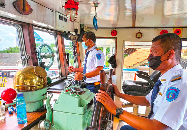 FOKUS: Mualim Kapal Joko Tole Rudi Habibi (kanan) menggerakkan kemudi saat berangkat menuju madura. Pengoperasian kapal legendaris itu dipimpin nakhoda Suhartono (kiri). (Eko Hendri/Jawa Pos) - Image