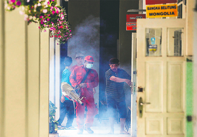 PENGASAPAN: Petugas melakukan fogging ke sekolah-sekolah untuk mencegah berkembang biaknya nyamuk yang mengakibatkan penyakit demam berdarah. (Dipta Wahyu/Jawa Pos) - Image