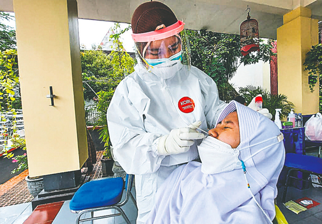 RUTIN PERIKSA: Siswa SMP 17 Agustus 1945 Surabaya sedang menjalani swab test. Tes itu dilakukan untuk memastikan tak ada klaster sekolah. (Galih Adi/Jawa Pos) - Image