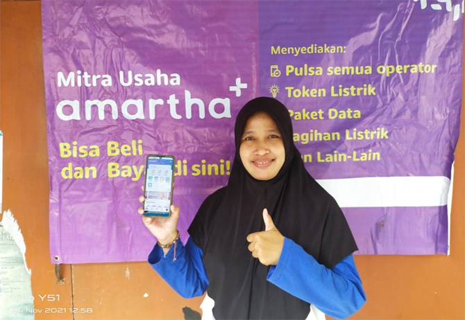 Ibu Riris (43) dari Kabupaten Terban, Kec. Gondokusuman, DIY Yogyakarta. Mitra Amartha berprestasi dan pengguna fitur PPOB Aplikasi Amartha Plus. (24/11) - Image