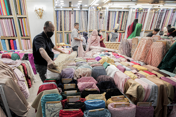 Pekerja menata bahan kain di Pasar Tanah Abang, Jakarta, Selasa (2/11/2021). Utilisasi industri tekstil dan produk tekstil atau TPT dalam negeri menunjukkan kinerja yang positif menjelang akhir 2021. Utilisasi industri itu berada di posisi 80-85% pada awa - Image