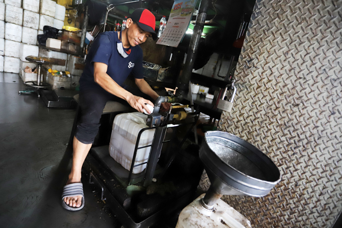 Pedagang saat mengisi minyak goreng curah ke dalam jerigen di salah satu agen minyak goreng di pasar Cipete, Jakarta, Jumat (26/11/2021). Pemerintah lewat Kementerian Perdaganganakan melarang penjualan minyak goreng curah mulai 1 Januari 2022 mendatang. - Image
