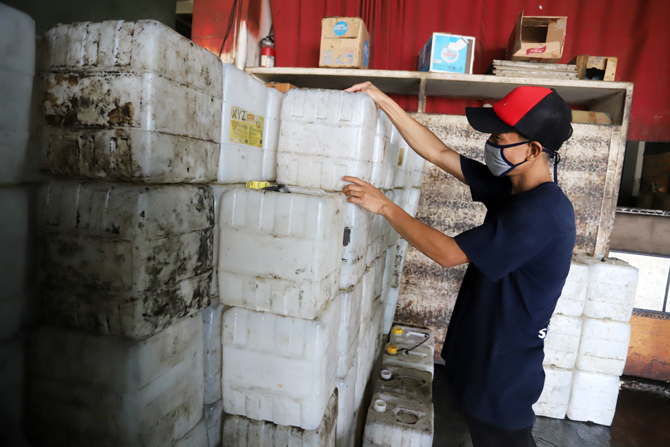 Pedagang saat mengisi minyak goreng curah ke dalam jerigen di salah satu agen minyak goreng di pasar Cipete, Jakarta, Jumat (26/11/2021). Pemerintah lewat Kementerian Perdaganganakan melarang penjualan minyak goreng curah mulai 1 Januari 2022 mendatang. - Image