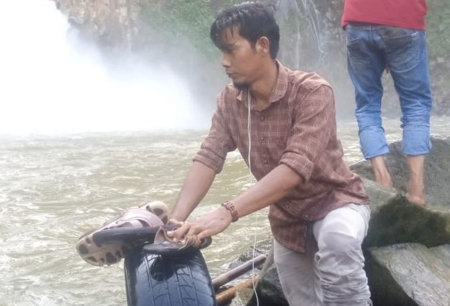 Warga memperlihatkan bagian ban mobil dan sandal perempuan di dalam Air Terjun Kedabuhan, Desa Jontor, Kecamatan Penanggalan, Kota Subulussalam, Aceh, Senin (13/12). Antara - Image